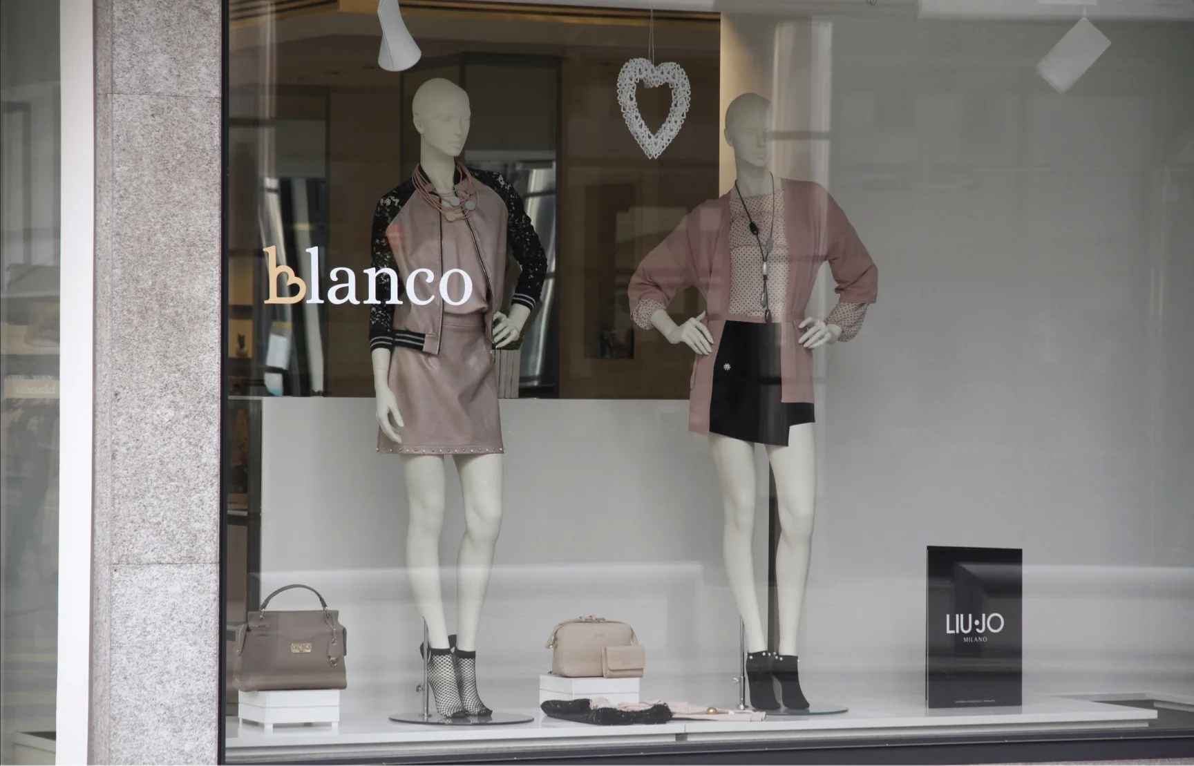Vetrina della boutique Blanco con due manichini e logo sul vetro